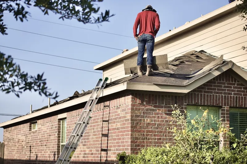 Professional roofer working on a residential roof in Heritage Greens